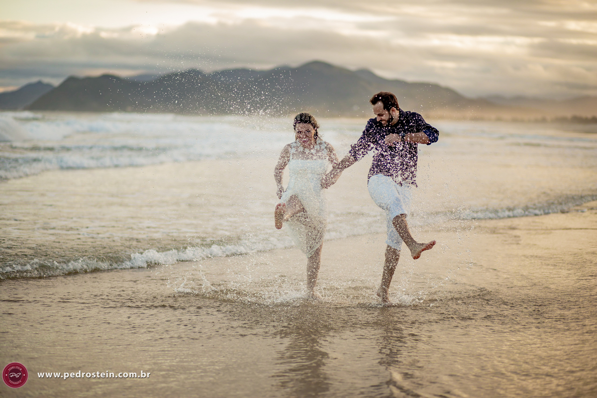 pedro stein fotografo de casamento em pre wedding na guarda do embau com noivos chutando a água na beira do mar