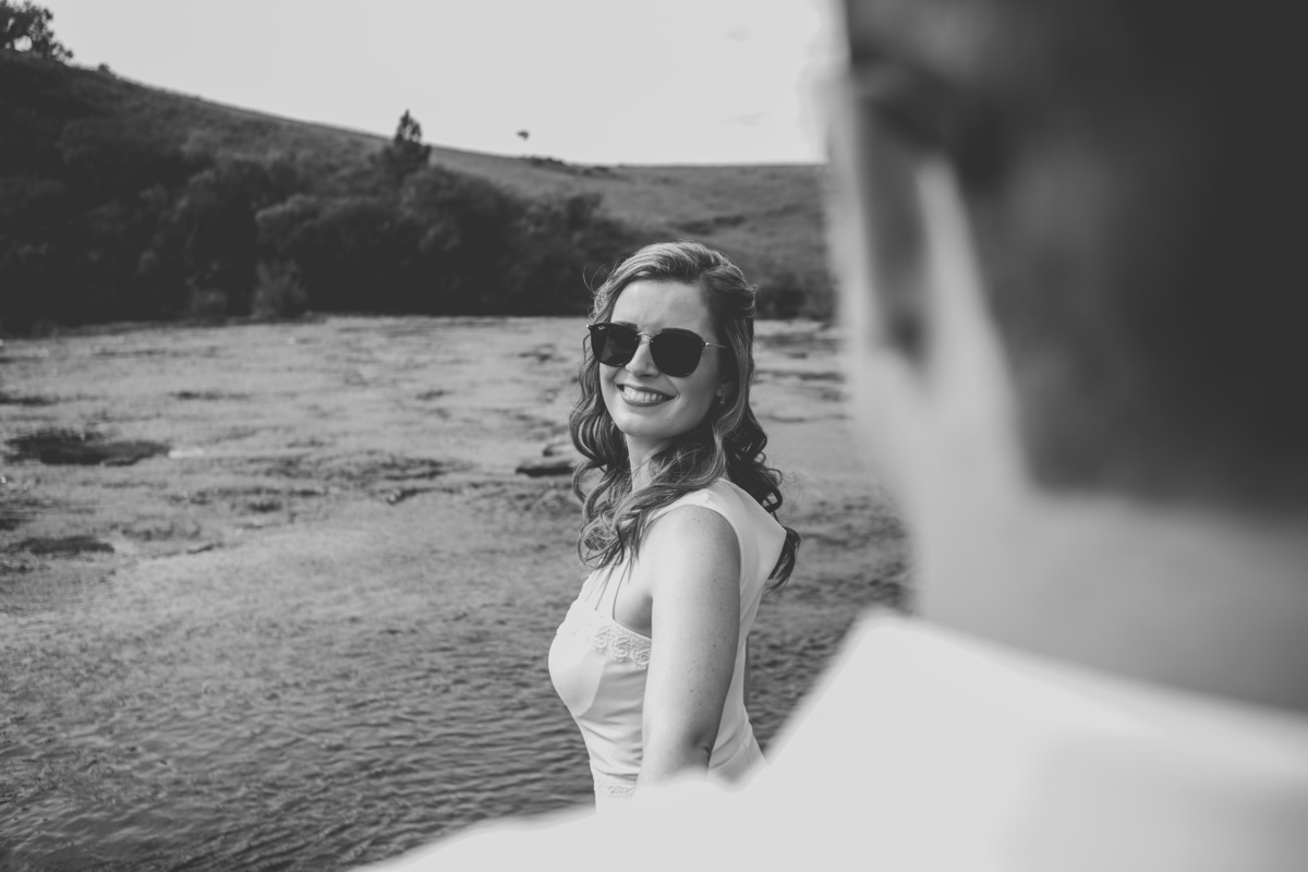 Fotógrafo de casamento de Cachoeirinha fotografia ensaio pré casamento detalhe da noiva olhando para o noivo de óculos escuros foto em preto e branco