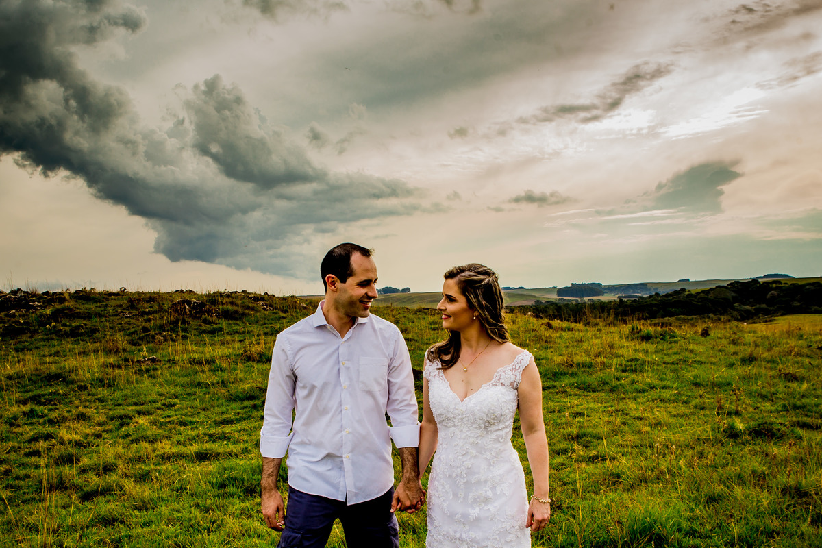 Fotógrafo de casamento de Cachoeirinha fotografia ensaio pré casamento casal de mãos dadas e se olhando no campo