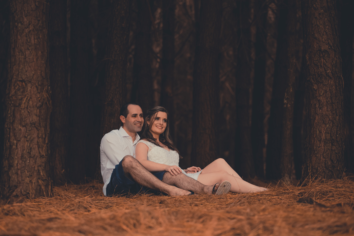 Fotógrafo de casamento de Cachoeirinha fotografia ensaio pré casamento casal sentado entre as árvores olhando para o horizonte