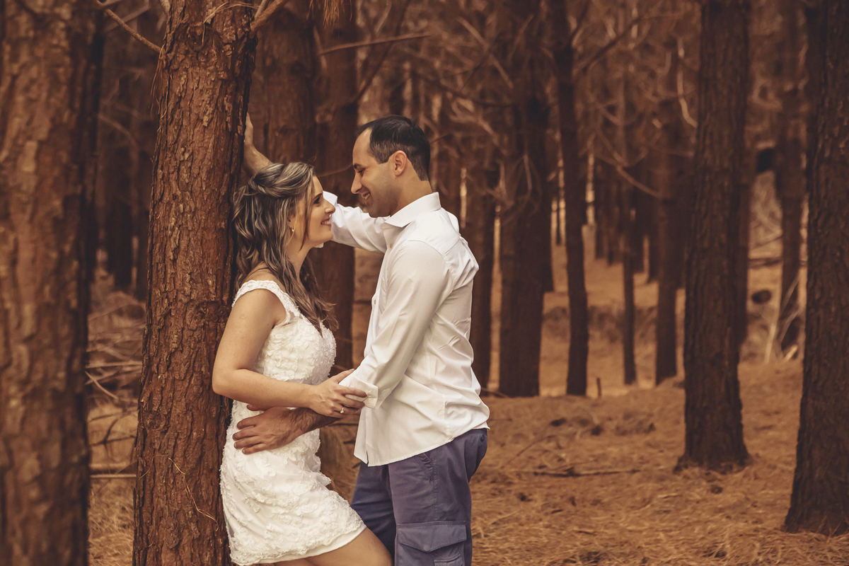 Fotógrafo de casamento de Cachoeirinha fotografia ensaio pré casamento noiva encostada na árvore olhando para o noivo imagem aberta