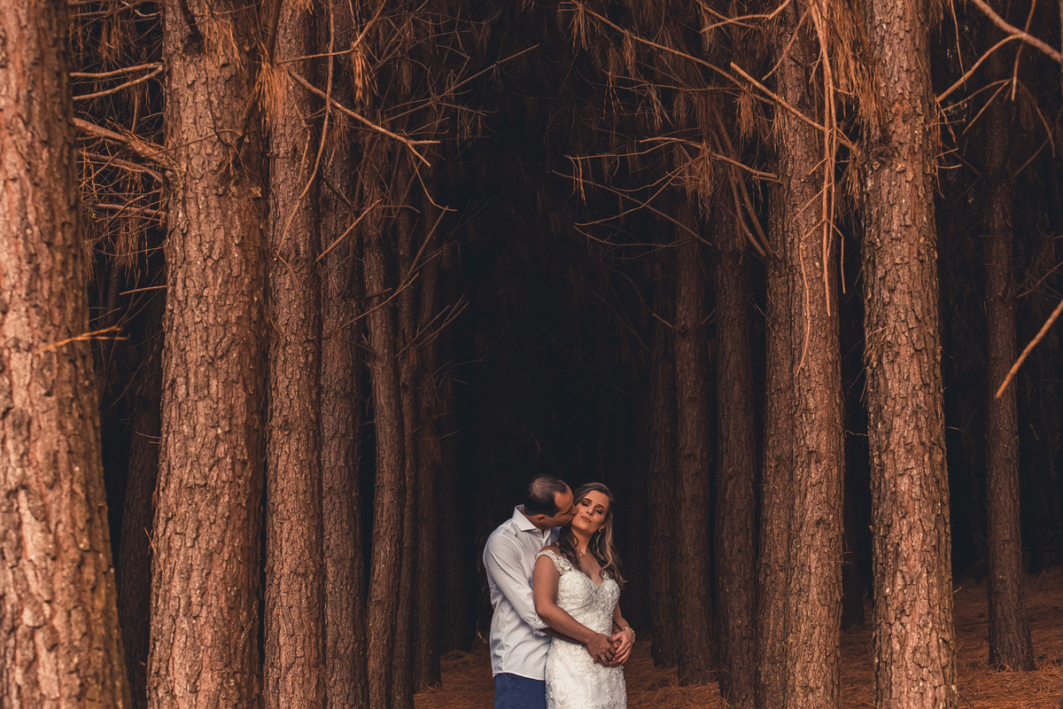 Fotógrafo de casamento de Cachoeirinha fotografia ensaio pré casamento casal entre as árvores noivo beijando a noiva por trás