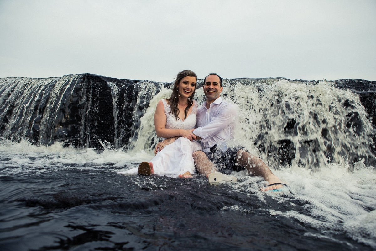 Fotógrafo de casamento de Cachoeirinha fotografia ensaio pré casamento casal sentado na pedra em frente a cachoeirinha