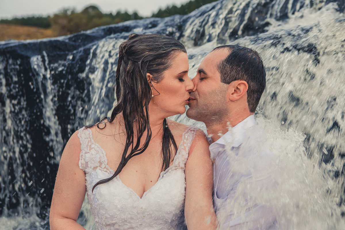Fotógrafo de casamento de Cachoeirinha fotografia ensaio pré casamento casal sentado no rio se beijando