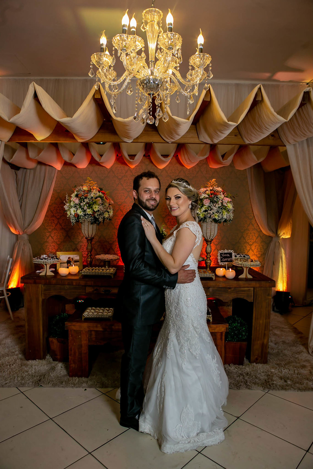 fotógrafo de casamento em cachoeirinha fotografia posada dos noivos de corpo inteiro em frente a mesa do bolo