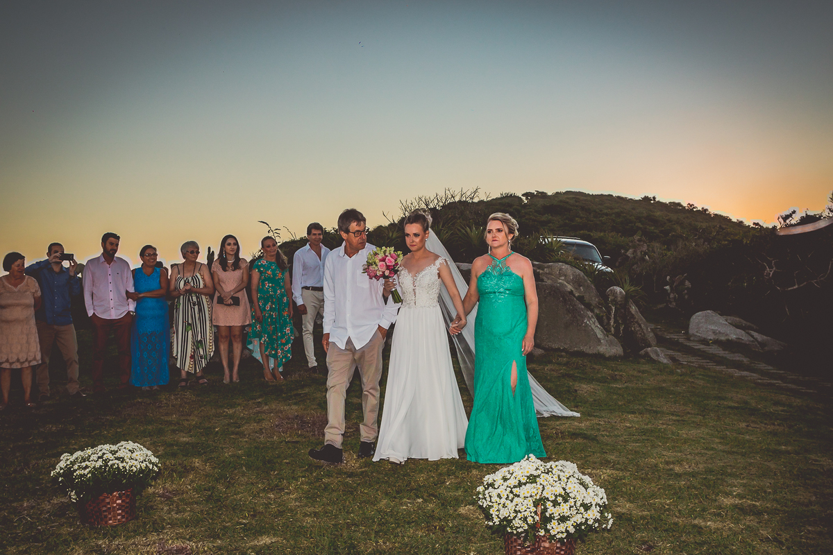 fotógrafo de casamento em cachoeirinha fotografia da noiva com seus pais e os convidados ao fundo