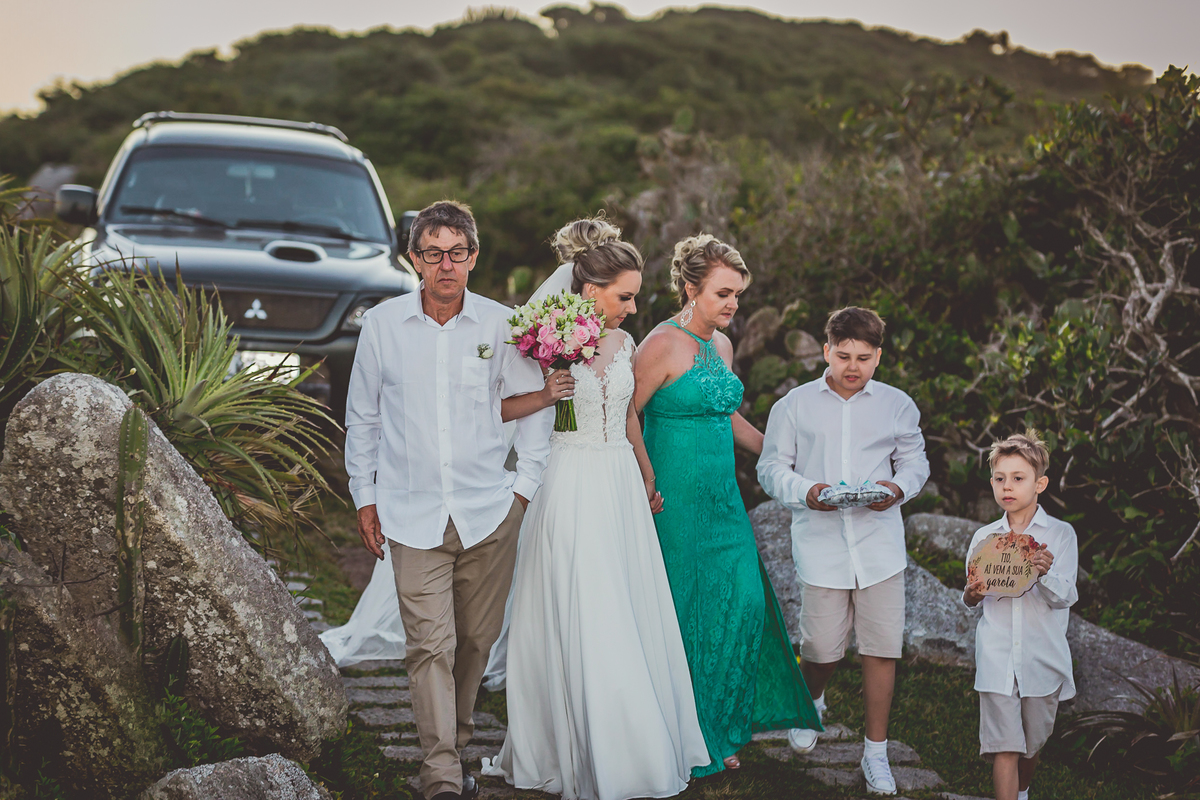 fotógrafo de casamento em cachoeirinha fotografia da noiva se colocando em posição de entrada com seus pais e os pajens