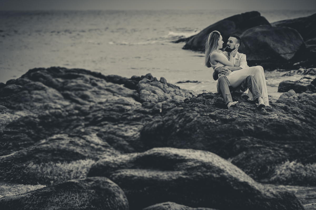 Fotógrafo de casamento de Cachoeirinha fotografia ensaio pré casamento casal sentado nas pedras em preto e branco