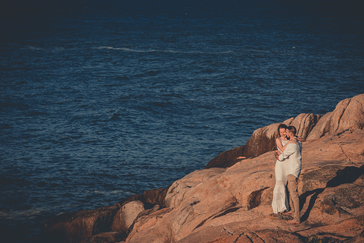 Fotógrafo de casamento de Cachoeirinha fotografia ensaio pré casamento casal abraçado nas pedras e o mar ao fundo