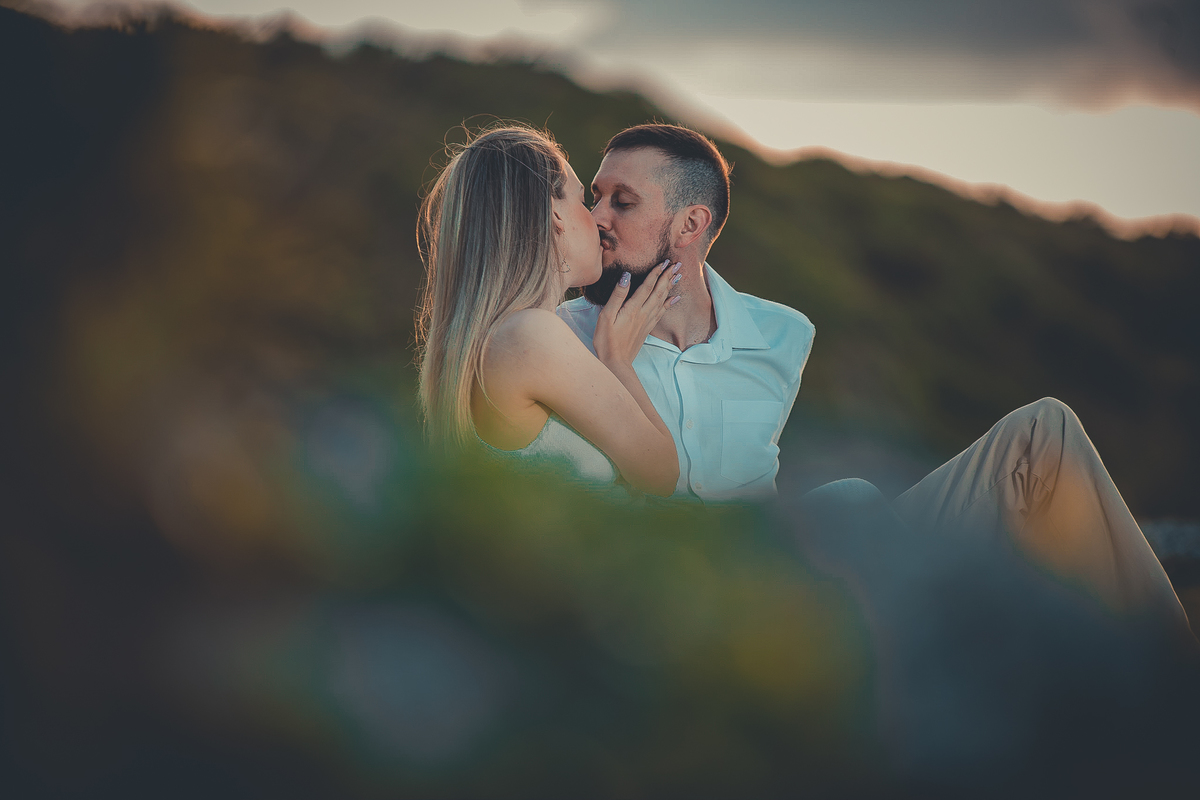 Fotógrafo de casamento de Cachoeirinha fotografia ensaio pré casamento casal sentado nas pedras no morro se beijando