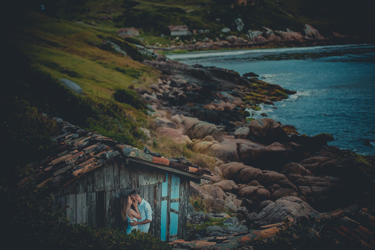 Fotógrafo de casamento de Cachoeirinha fotografia ensaio pré casamento casal atrás de uma casinha na beira das pedras e do mar