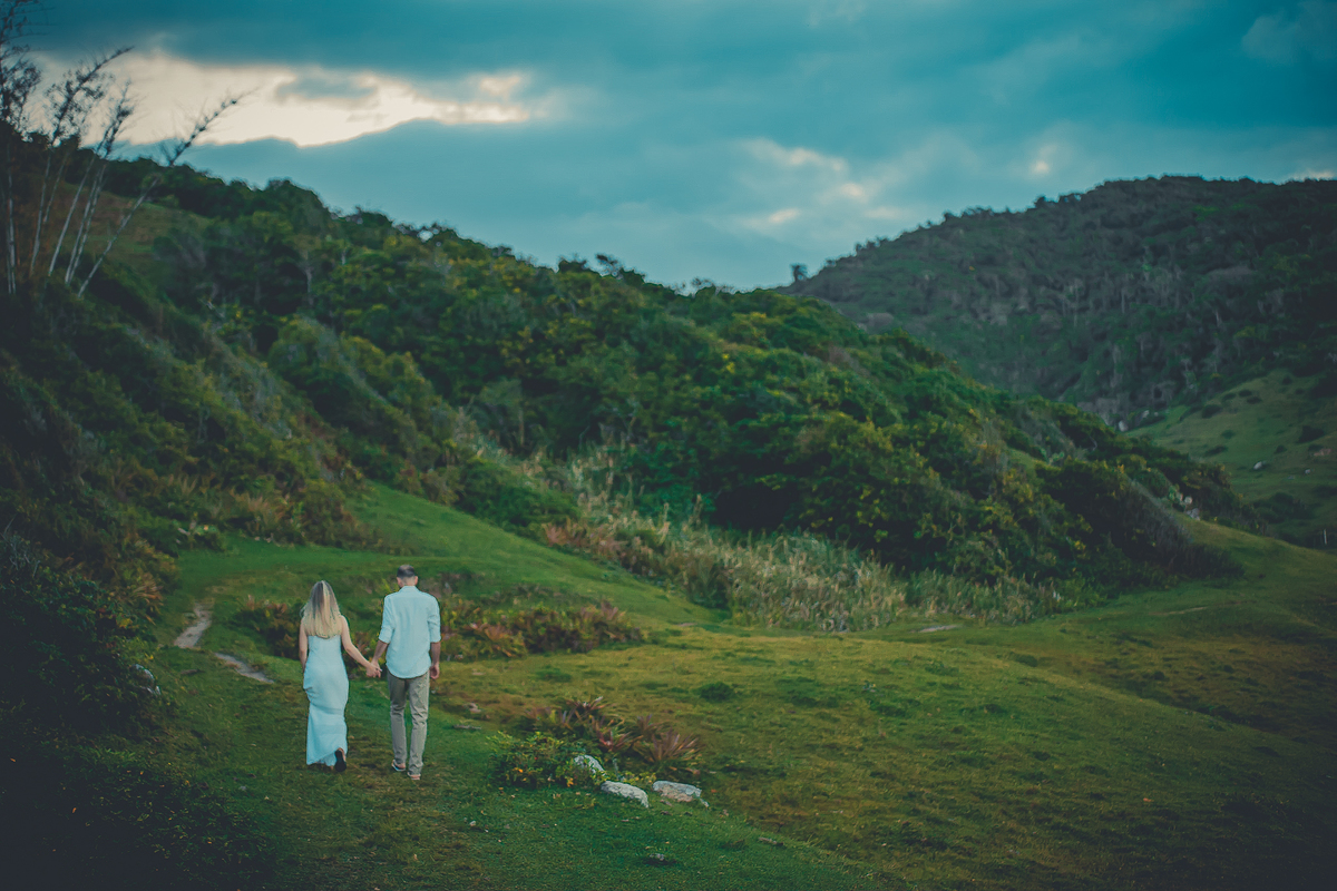 Fotógrafo de casamento de Cachoeirinha fotografia ensaio pré casamento casal de costas andando de mãos dadas no campo 