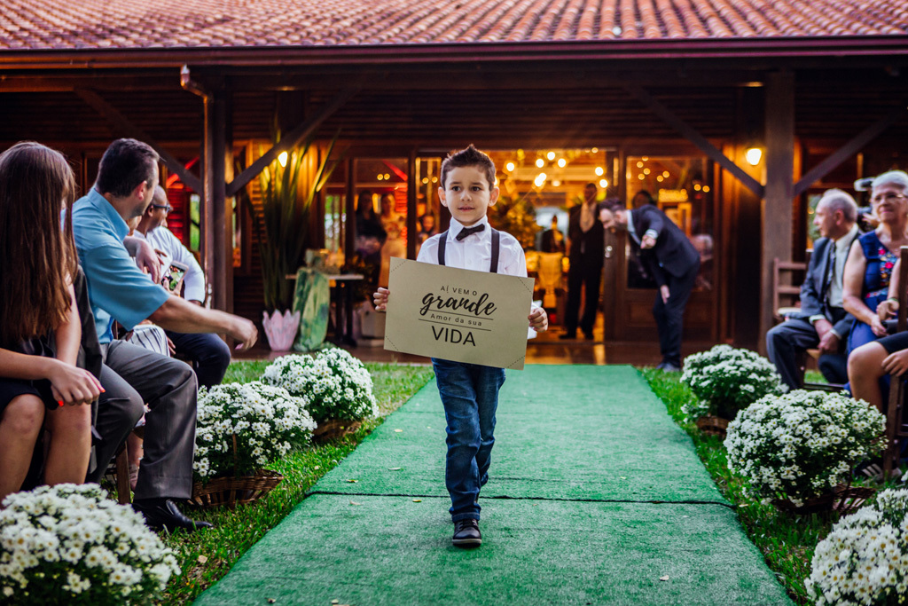 fotógrafo de casamento em cachoeirinha e porto alegre fotografia do page entrando com um cartaz