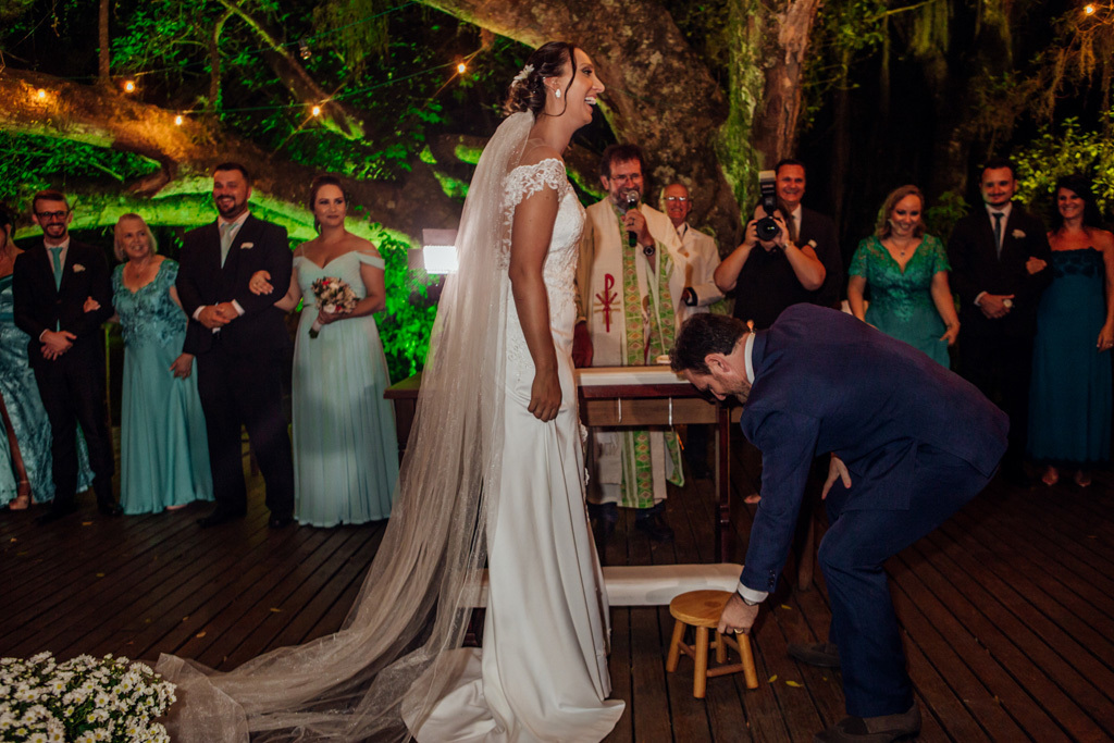 fotógrafo de casamento em cachoeirinha e porto alegre fotografia do noivo pegando um banquinho para subir nele e beijar a noiva
