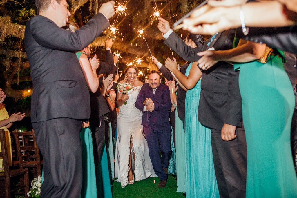 fotógrafo de casamento em cachoeirinha e porto alegre fotografia dos padrinhos com varinhas luminosas em corredor para receber os noivos