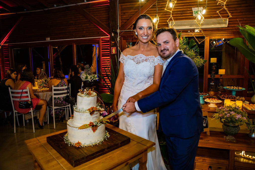 fotógrafo de casamento em cachoeirinha e porto alegre fotografia dos noivos em frente ao bolo de casamento