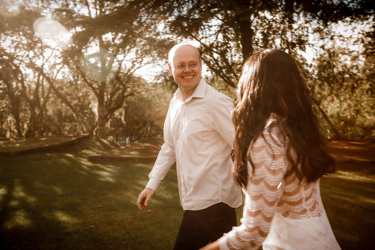 ensaio de casal, ensaio pre casamento, fotografia de casamento, noivos correndo e em primeiro plano o noivo sorrindo para a noiva