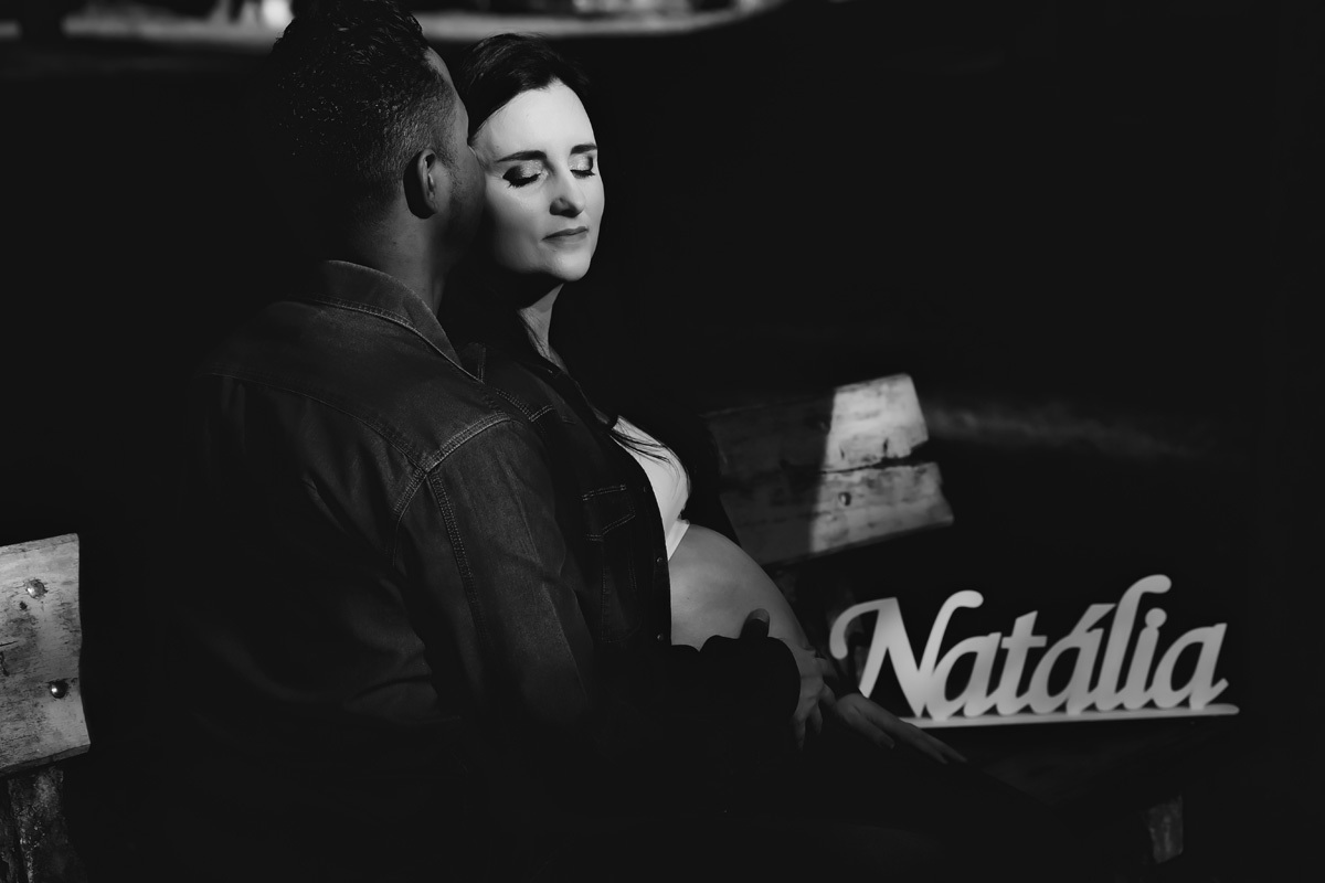 book de gestante em preto e branco pai dando beijo no rosto da esposa