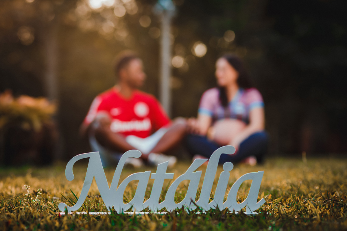 book de gestante com casal ao fundo e nome natalía em primeiro plano