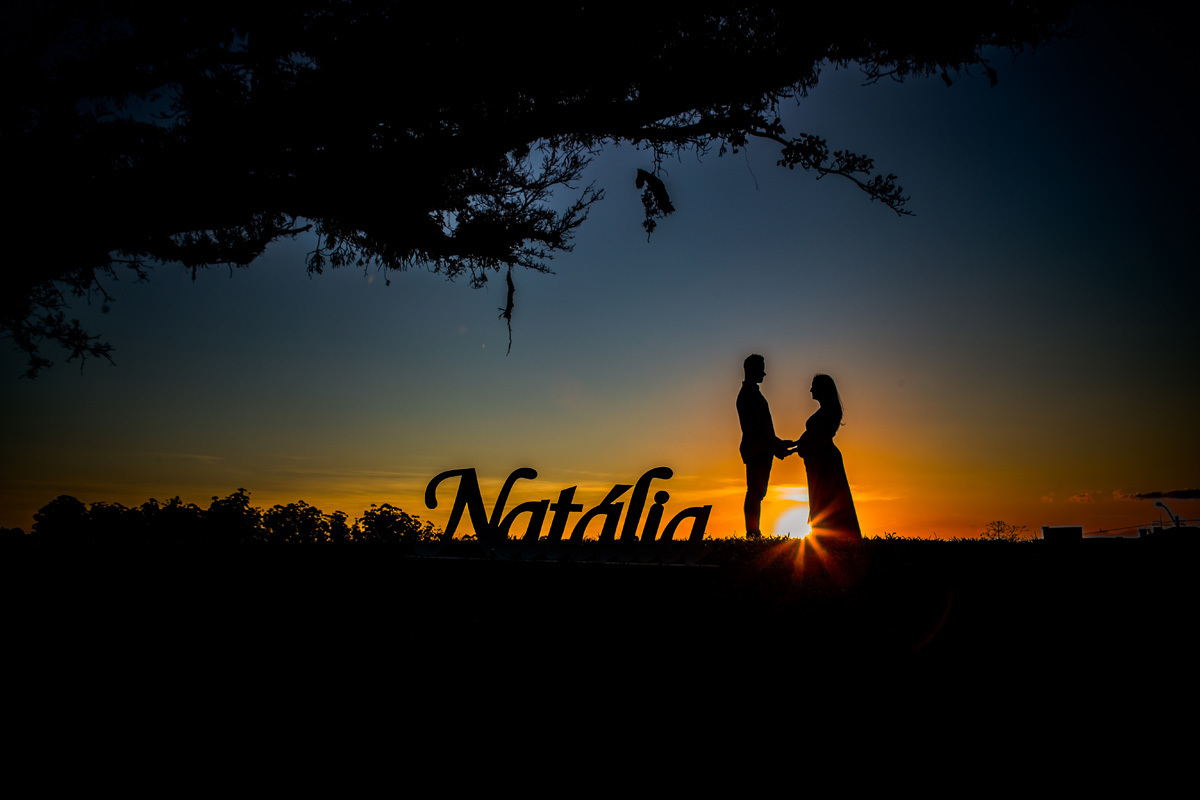 book de gestante com fotografia de arvore e casal em silhueta com o nome natália em primeiro plano