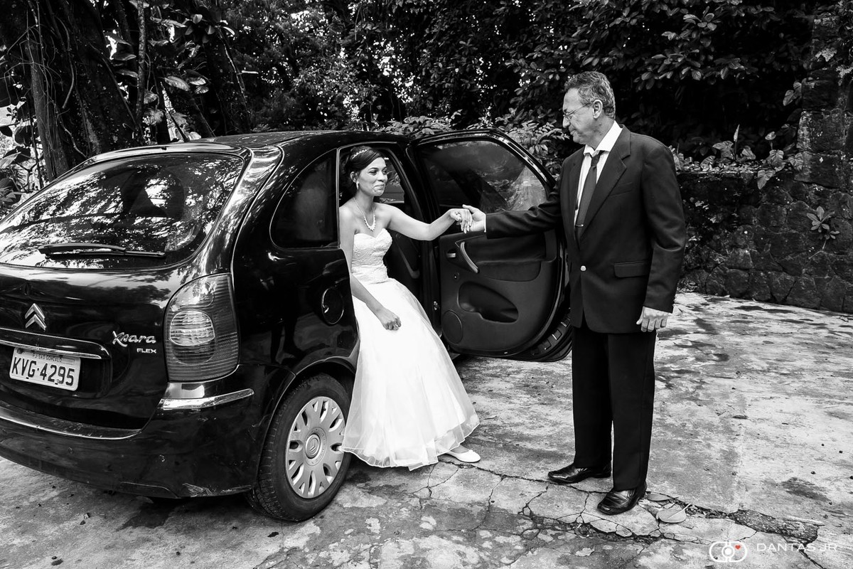 noiva saindo do carro com pai dando a mão em foto preto e brando por Dantas Jr.