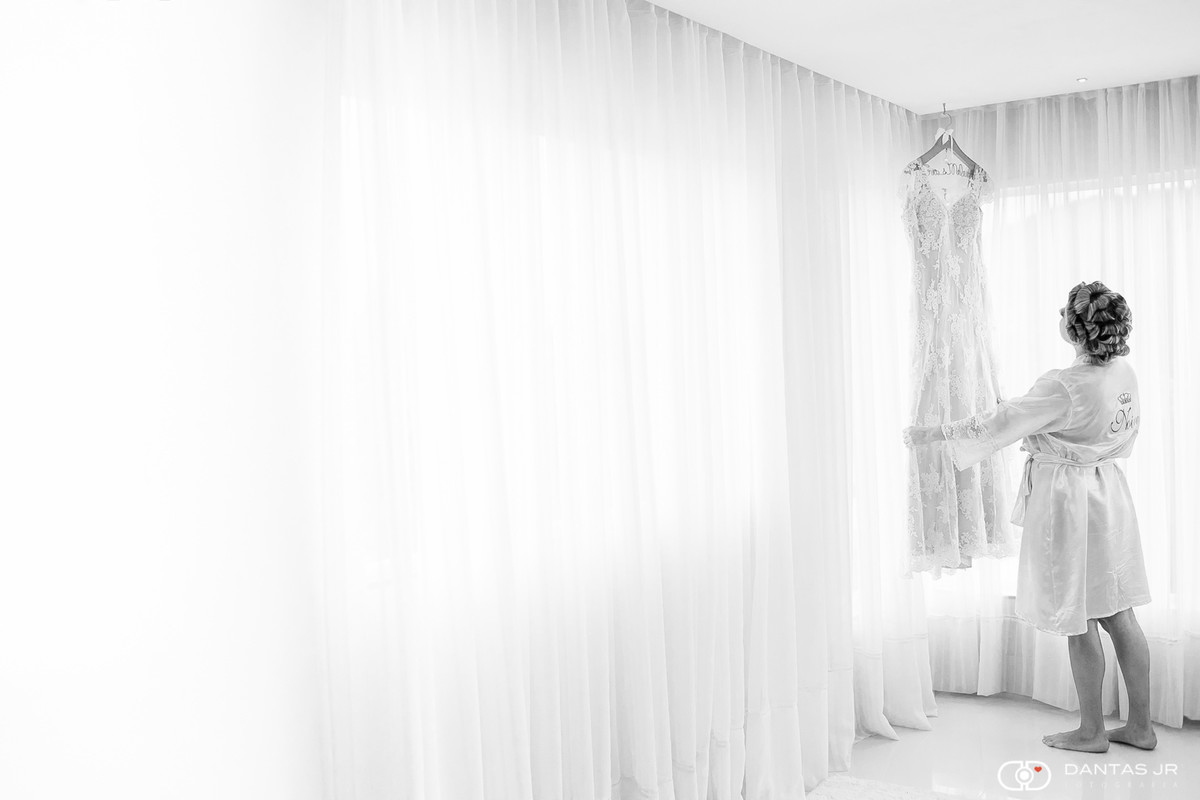Noiva casamento homoafetivo lésbica admirando vestido pendurado em making of por Dantas Jr. Fotografia