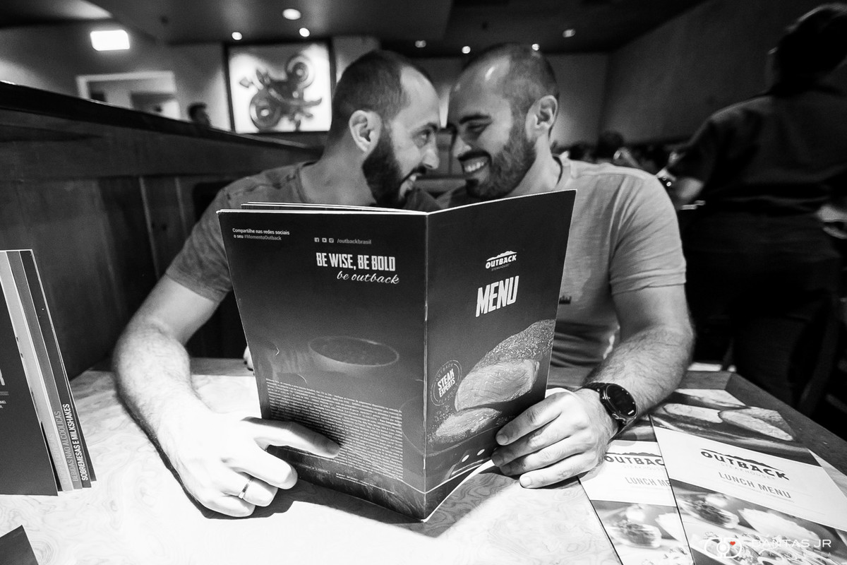 Casal gay de dois homens em ensaio pre weddinh homoafetivo olhando o cardapio e se beijando no Outback no Rio de Janeiro por Dantas Jr Fotografia