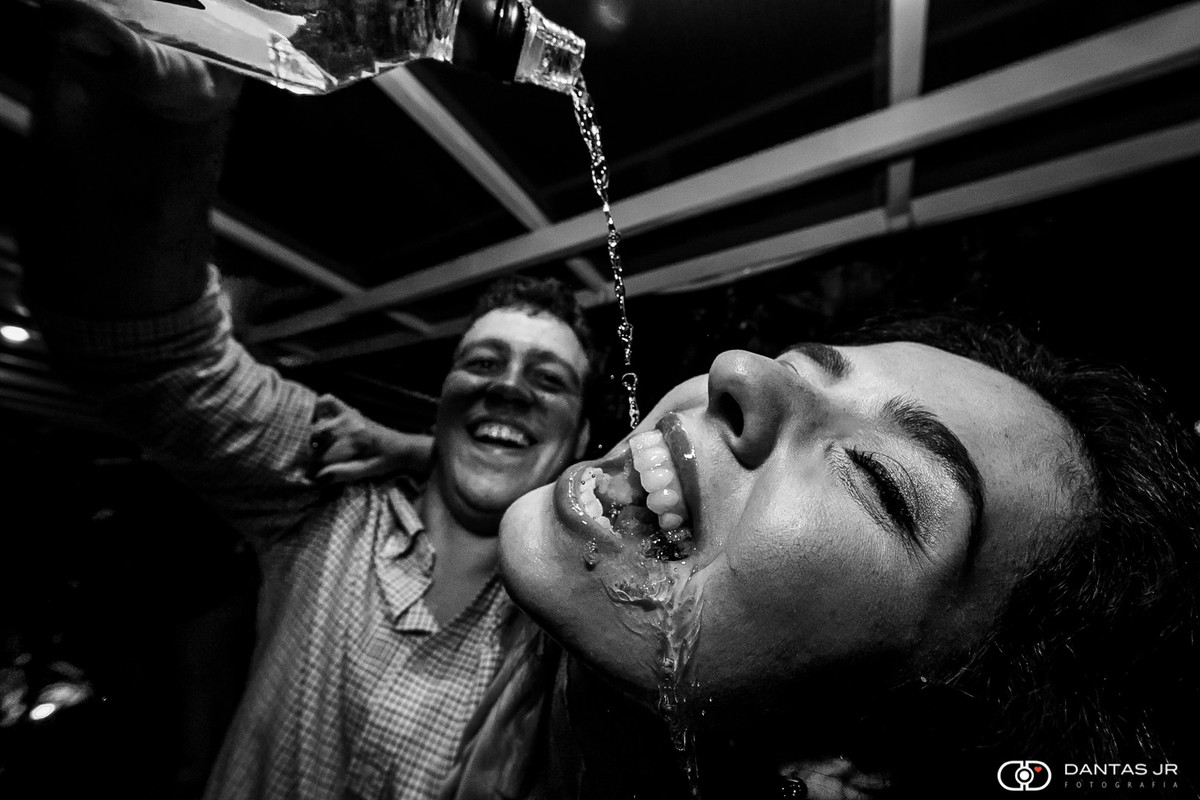 Noiva recebendo dose de whisky direto da garrafa na pista de dança em festa de casamento judaico ao ar livre de dia no solar das palmeiras na ilha da gigoia barra da tijuca no RJ por Dantas Jr.