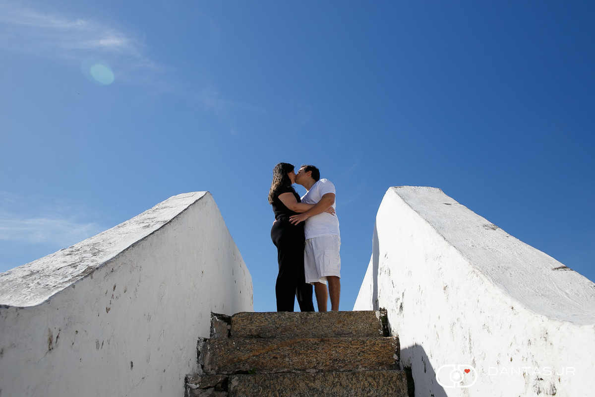 casal se beijando no alto da escada em céu azul na fortaleza santa cruz em niteroi por Dantasd Jr.