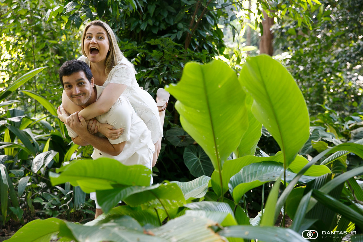 Casal brincando e noivo carregando noiva nas costas em ensaio romântico no Parque Lage por Dantas Jr.