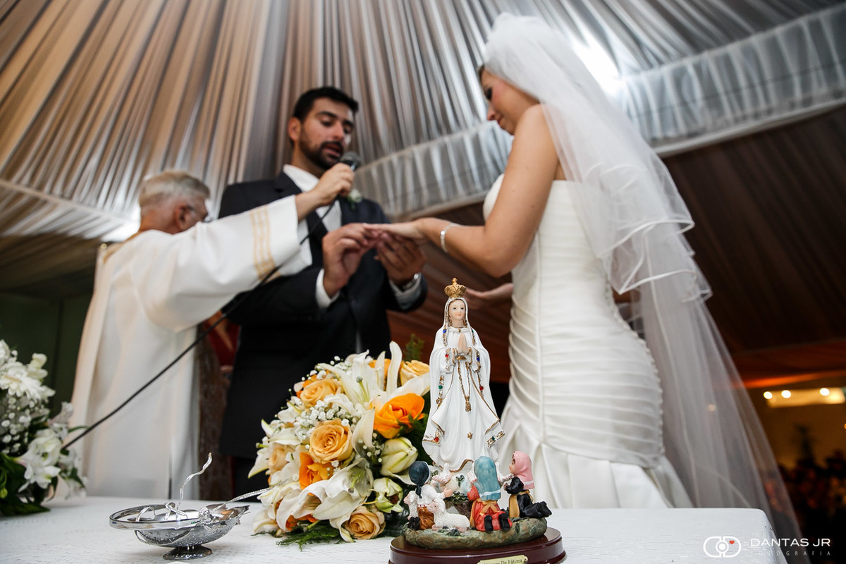 Casal troca alianças de casamento diante imagem de nossa senhora de fátima em cerimonia na casa do alto por dantas jr.