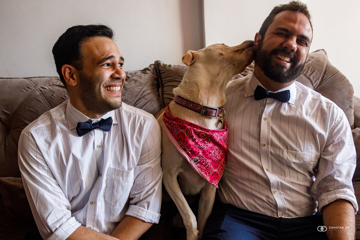 casal gay com cachorro lambendo rosto de um dos noivos