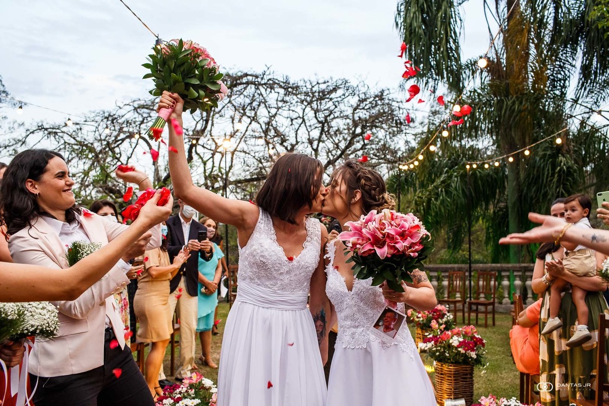 noivas se beijando na saída de cerimônia em casamento ao ar livre por Dantas Jr.