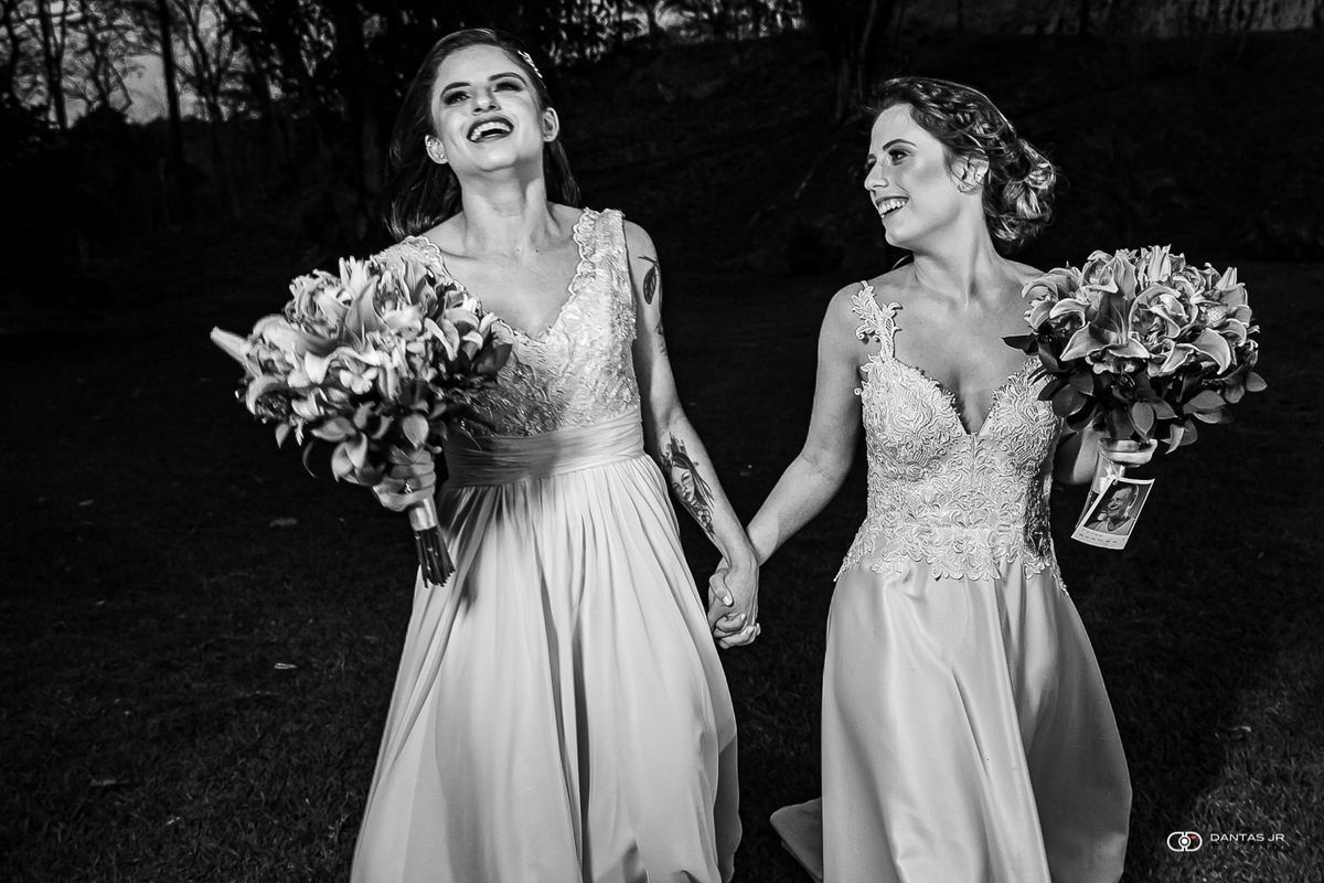 noivas correndo ao ar livre pelo campo em casamento gay ao ar livre por Dantas Jr.