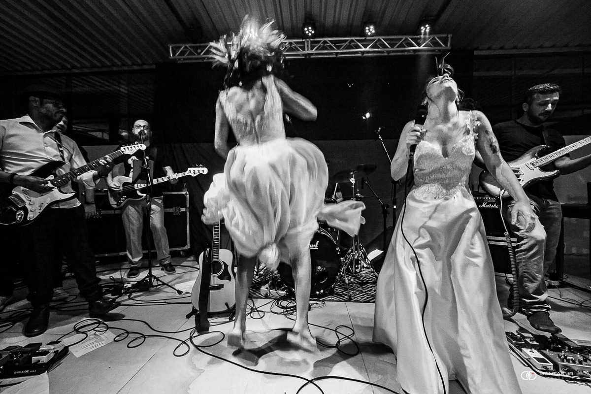 casal de noivas pulando no palco em casamento homoafetivo com banda tocando rock'n'roll por Dantas Jr.