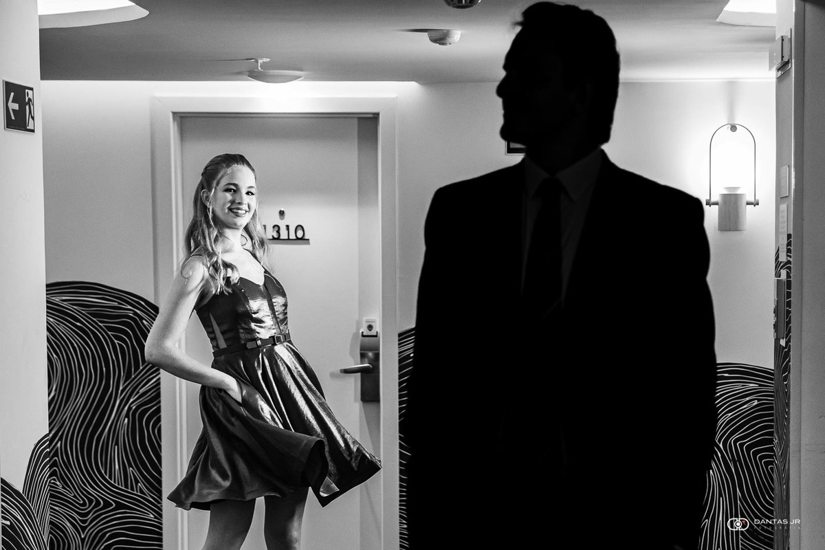 silhueta de pai de debutante no corredor do hotel enquanto ela posa  por Dantas Jr.