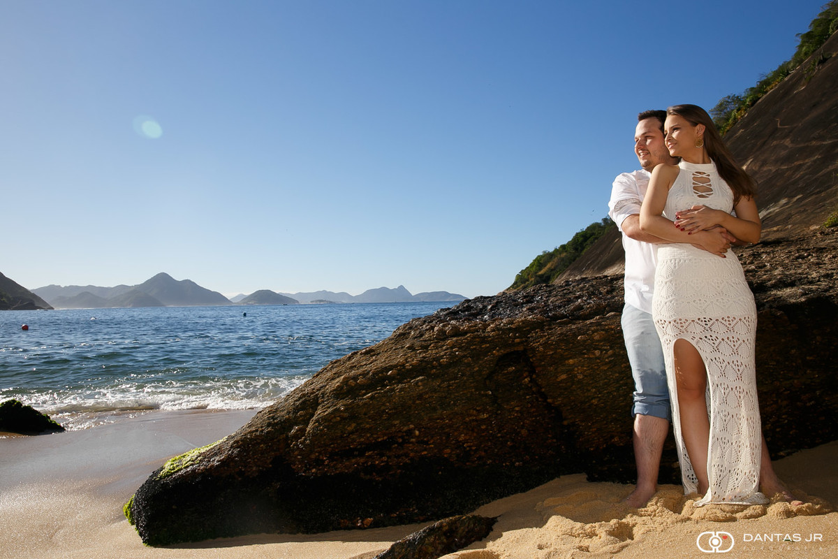 Casal encostado em pedra na praia vermelha deserta em ensaio pre wedding por Dantas Jr, Fotografia