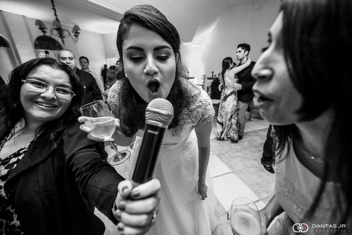 Noiva cantando feliz com microfone em festa de casamento animada na igreja de Santa Ignês no Rio de Janeiro por Dantas Jr. Fotografia