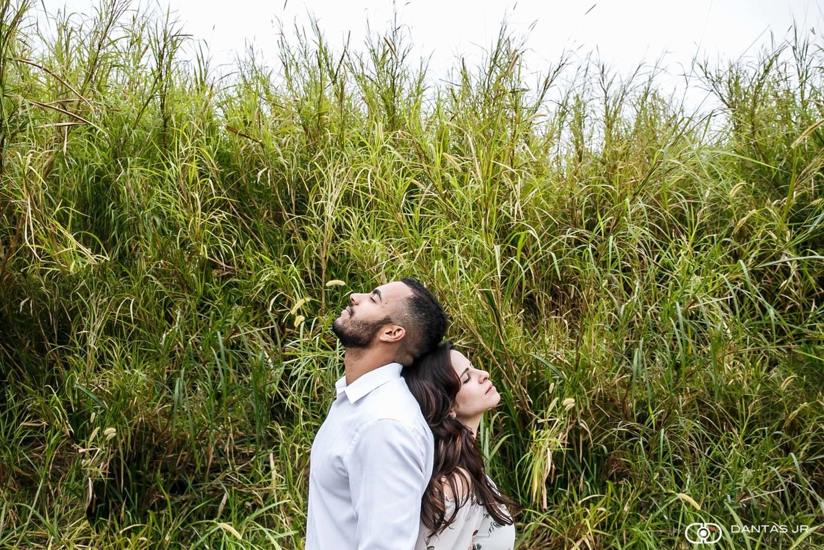 casal no meio de plantação de milho de costas pro outro em ensaio pre wedding por Dantas Jr. Fotografia