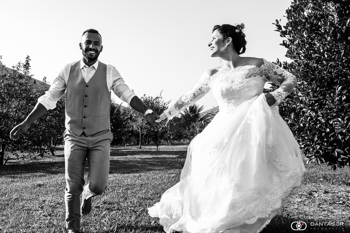 ensaio trash the dress com Noiva correndo em gramado de fazenda puxando noivo e olhando pra ele em Vassouras por Dantas Jr. Fotografia
