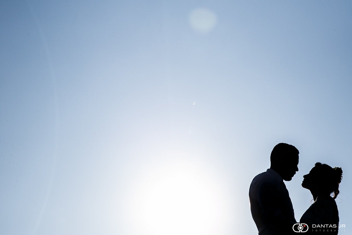 ensiao trash the dress com casal em silhueta e céu azul por Dantas Jr Fotografia