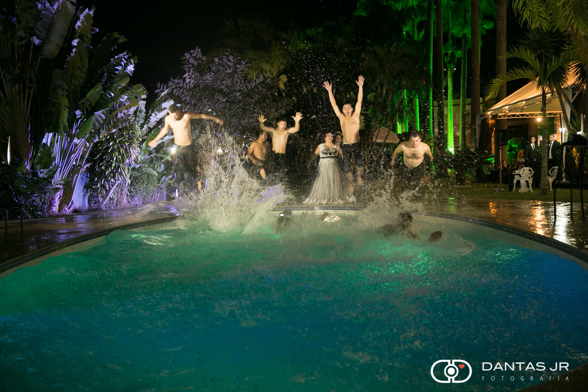 noivos e convidados pulando na piscina