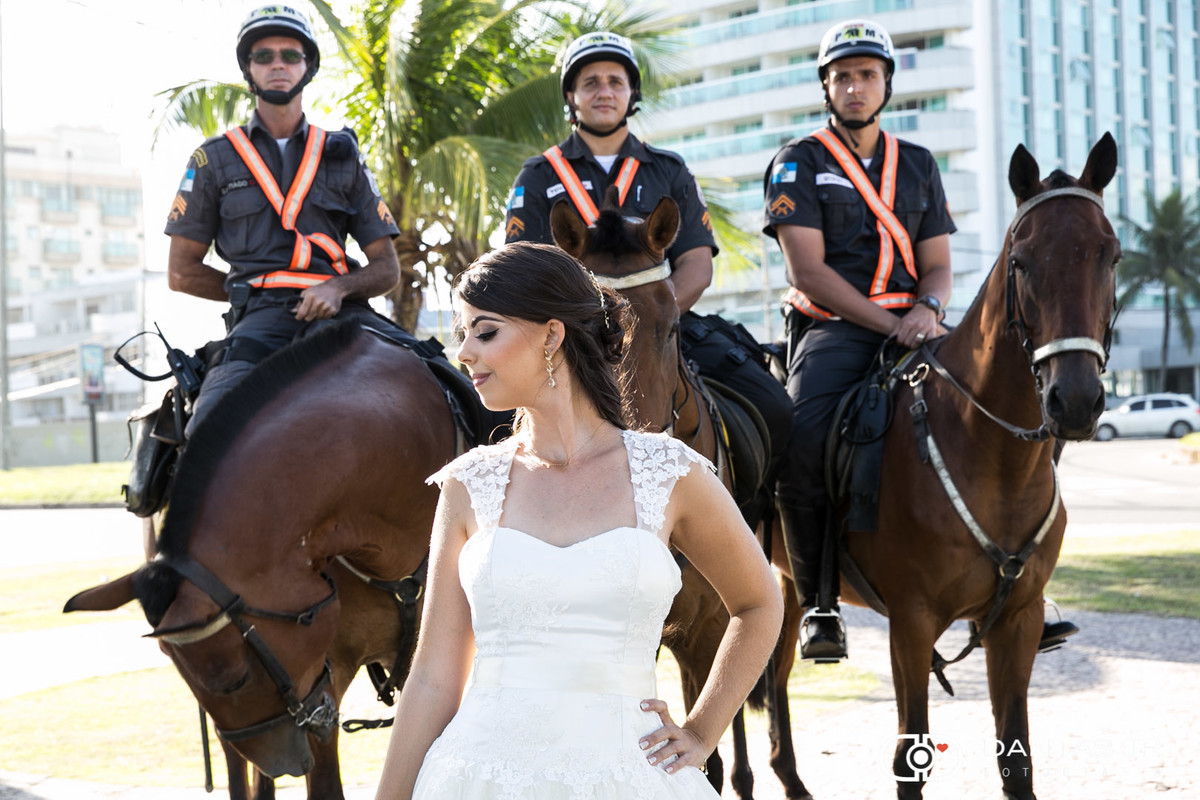noiva na praia em frente a cavalos e policiais por Dantas Jr.