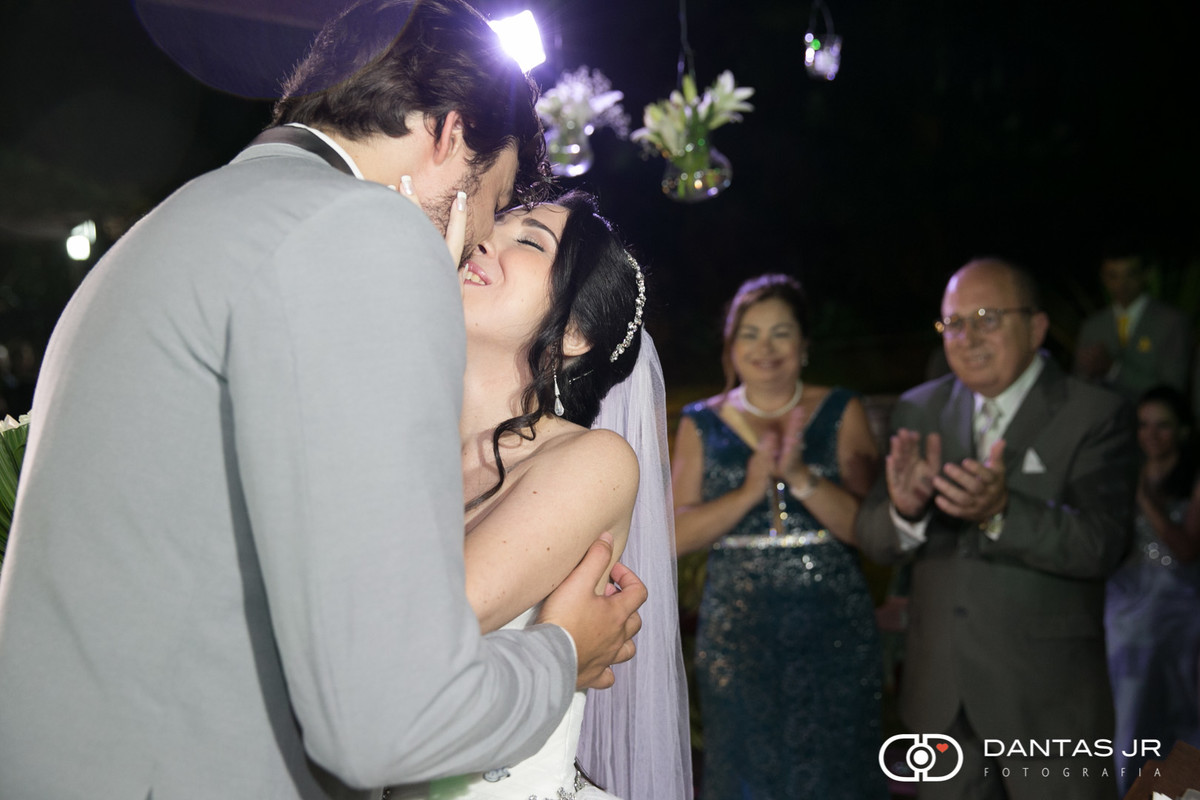 noivos se beijando e pais observando felizes