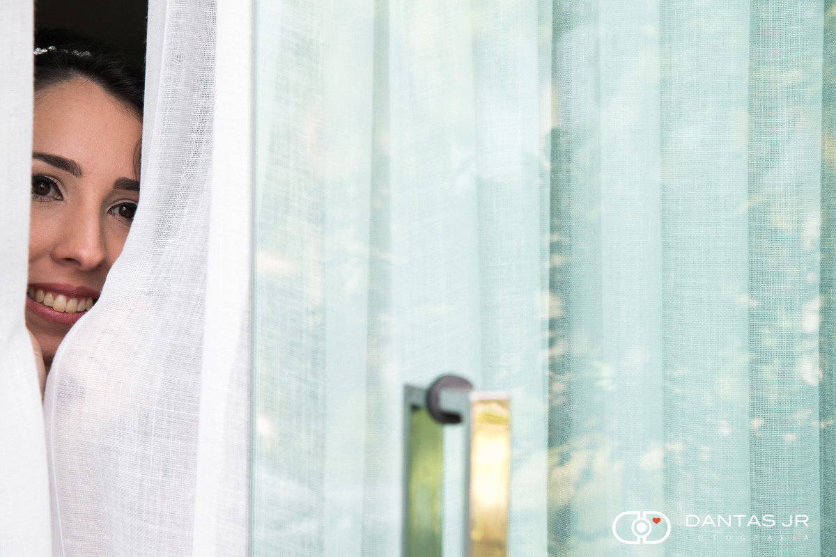 noiva olhando através de cortina