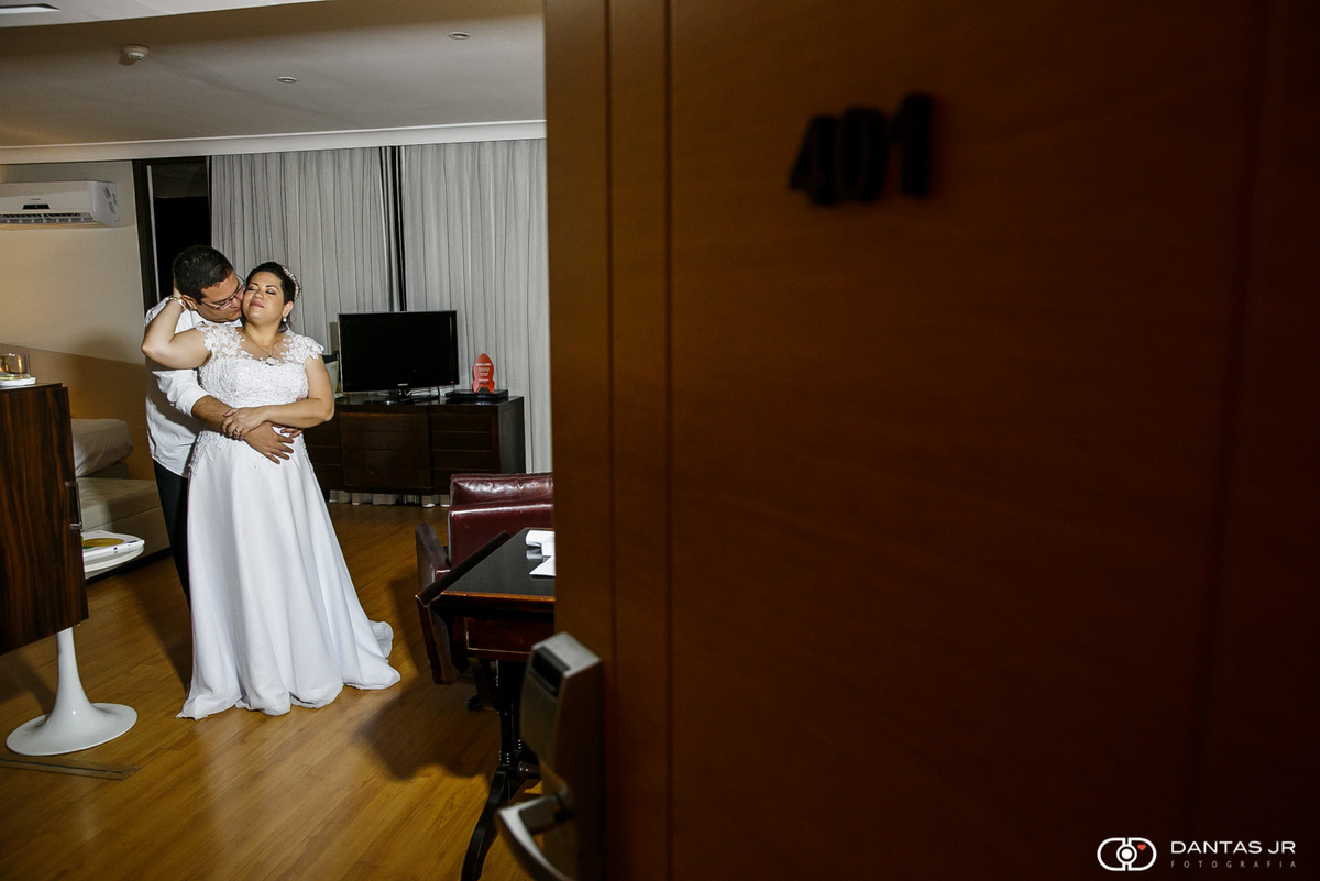 casal de noivos vistos pela porta do hotel se fechando em copacabana em ensaio pos wedding apos festa no coliseum eventos com trash the dress feito pelo melhor fotografo do RJ Dantas Jr Fotografia