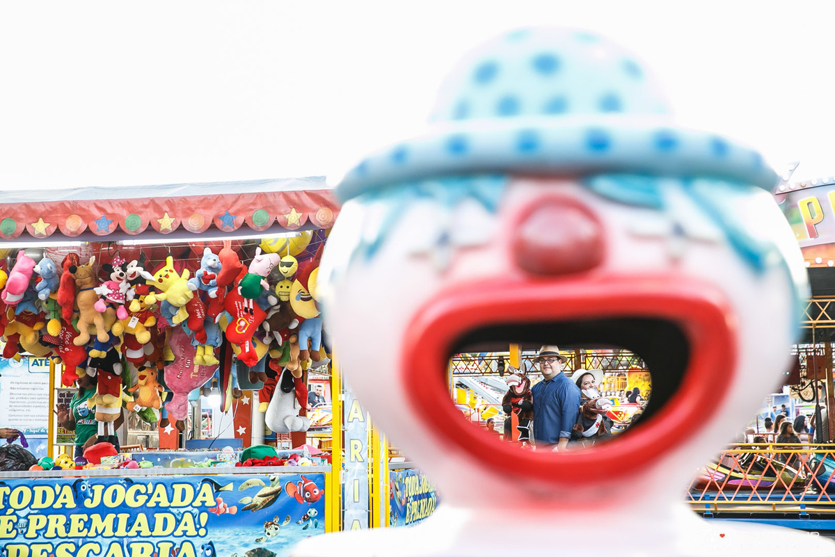 Casal namorando vistos através da boca do palhaço num parque de diversões