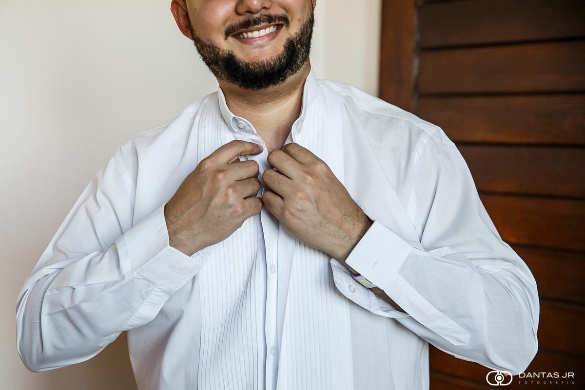 noivo se arrumando e fechando camisa em making of