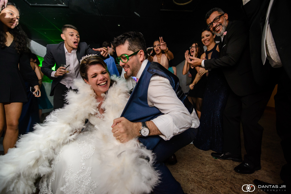 noiva e noivo fantasiados com acessórios de pista dançando e indo até o chão