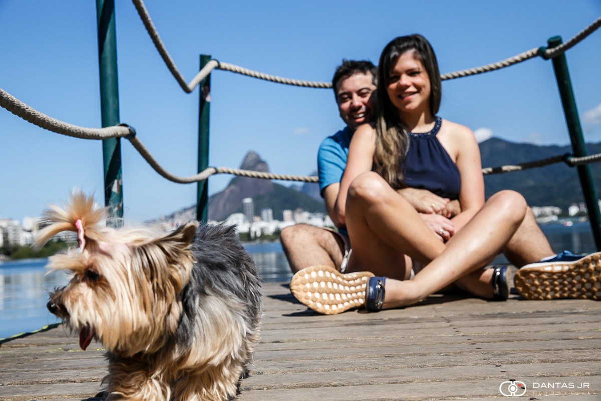 casal de namorados em ensaio de noivos prewedding sentados na Lagoa Rodrigo de Freitas com cachorro brincando